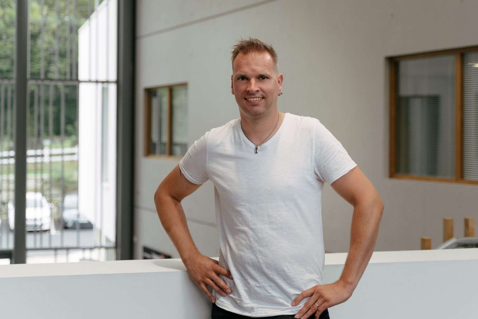 Portrait d'un homme grand et blond portant un t-shirt blanc