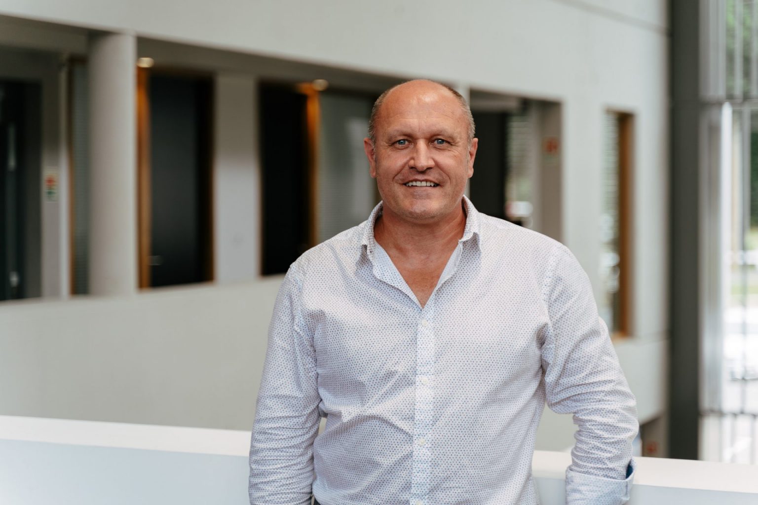 Portrait d'un homme souriant portant une chemise blanche