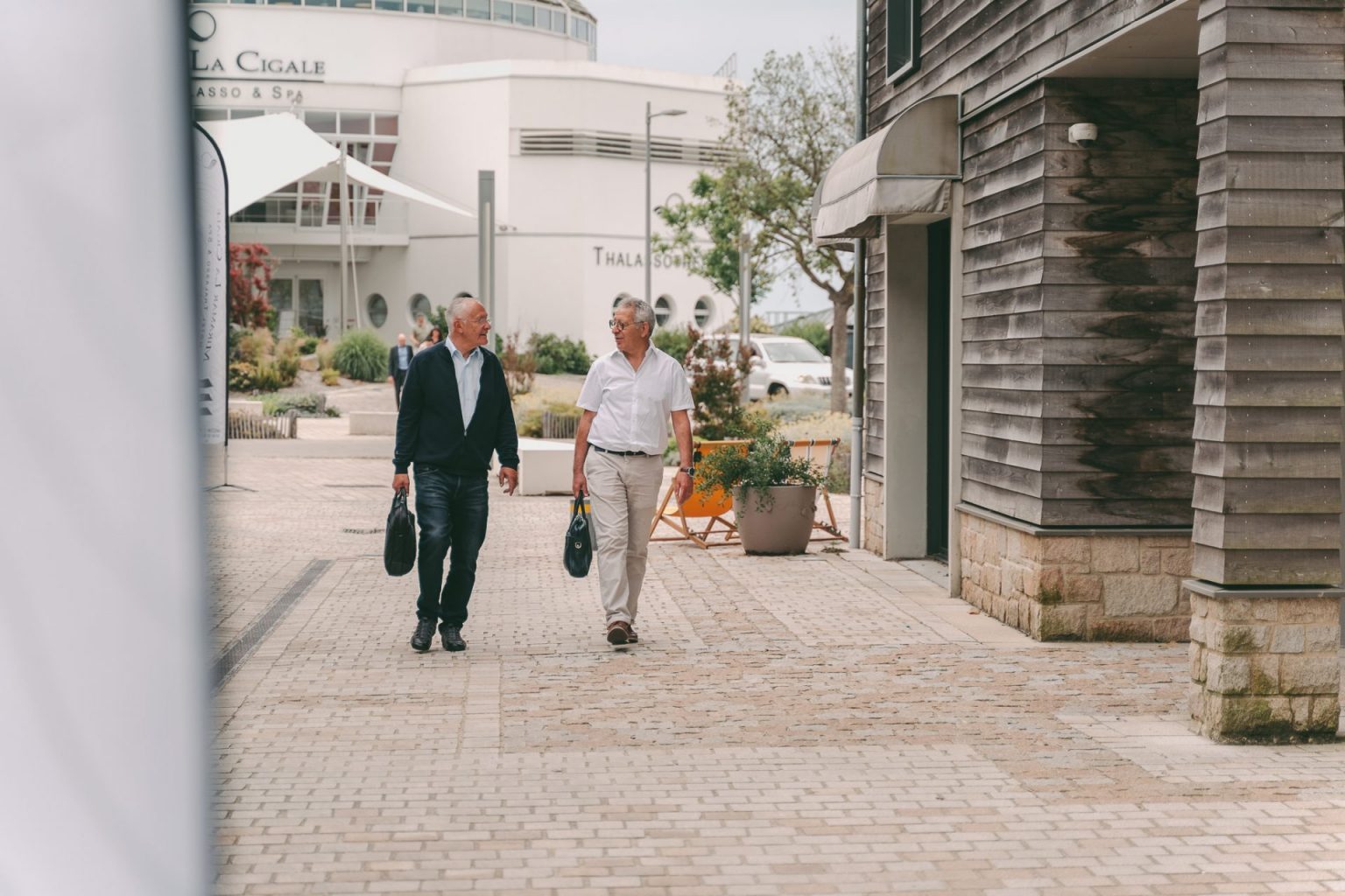 Photographie d'entreprise sur laquelle on voit deux hommes qui marchent ensemble en allant à une réunion