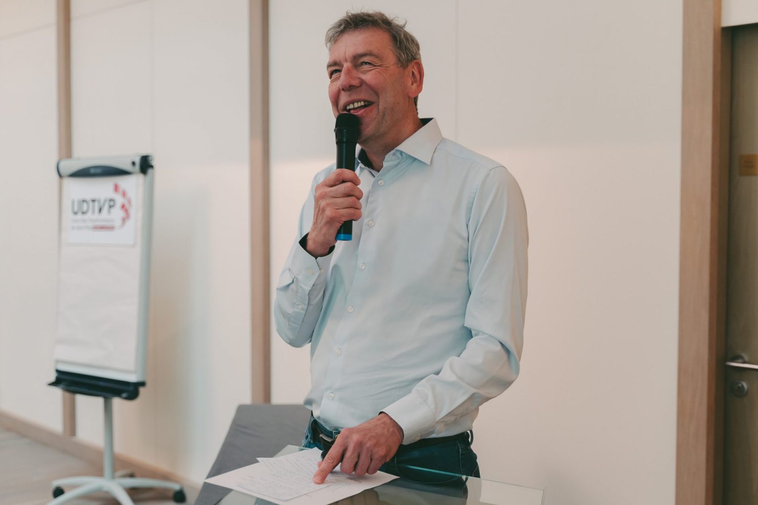 Photographie d'entreprise sur laquelle on voit un conférencier, micro à la main, entrain d'animer une réunion de travail