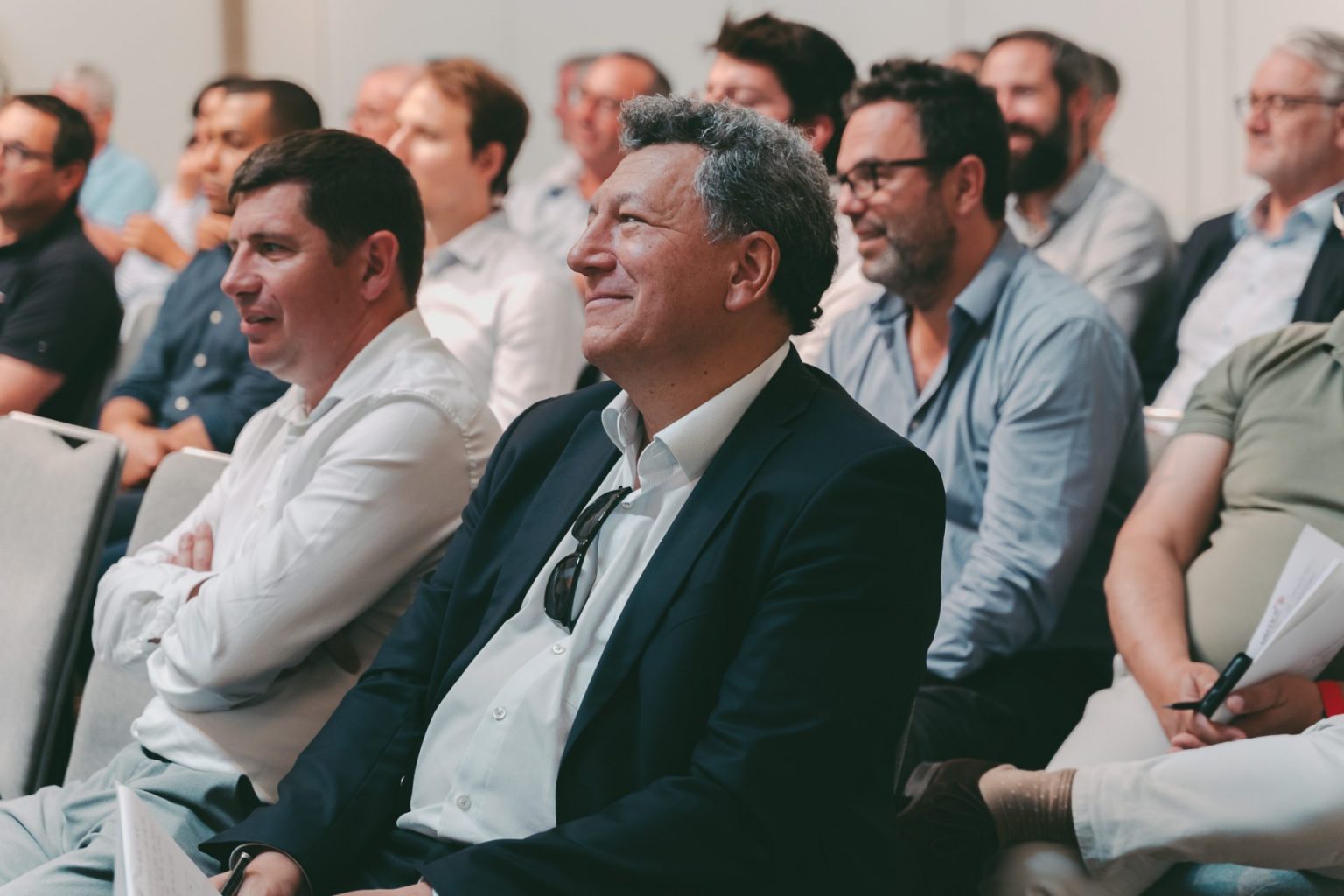Photographie d'entreprise sur laquelle on voit une assemblée de personne qui assiste à une réunion