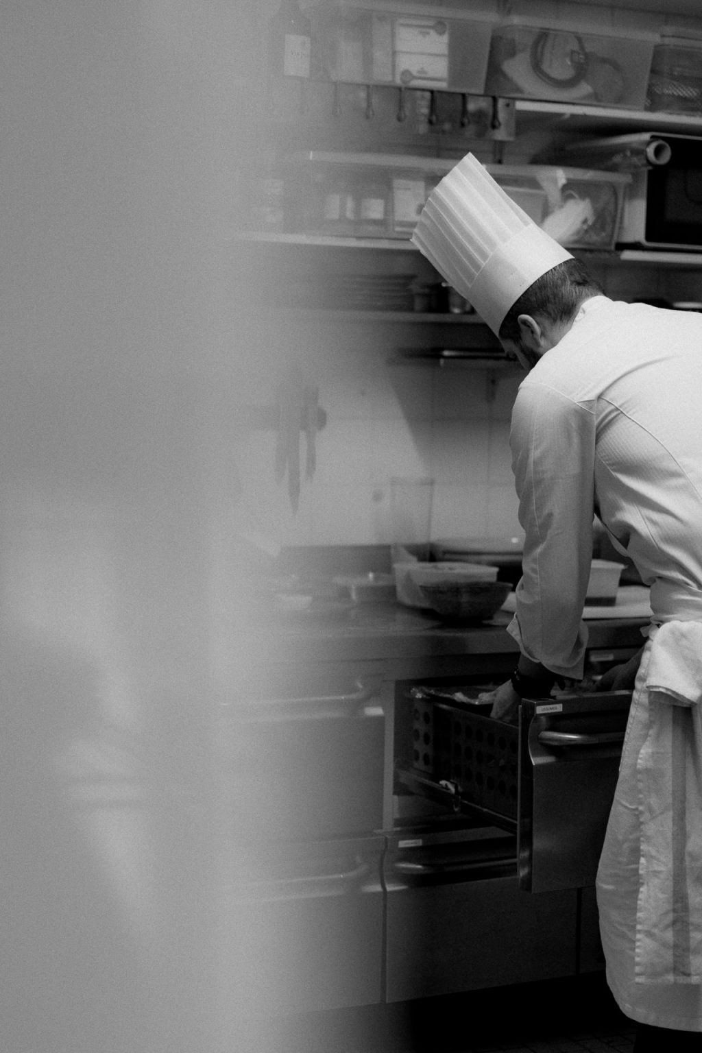 Photographie en noir et blanc d'un restaurateur en cuisine