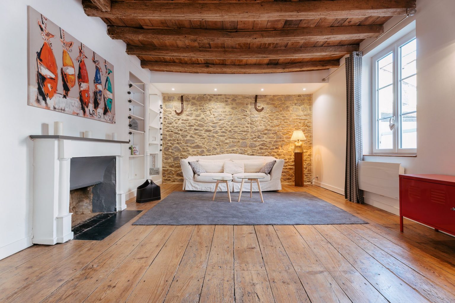 Photographie du salon d'un appartement avec un mur en pierre dans le centre ville de Vannes