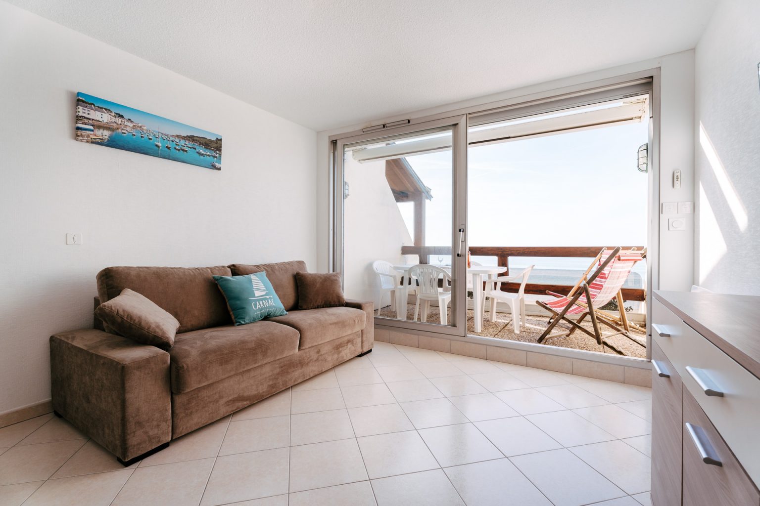 Photographie d'un salon donnant sur une terrasse avec vue sur mer