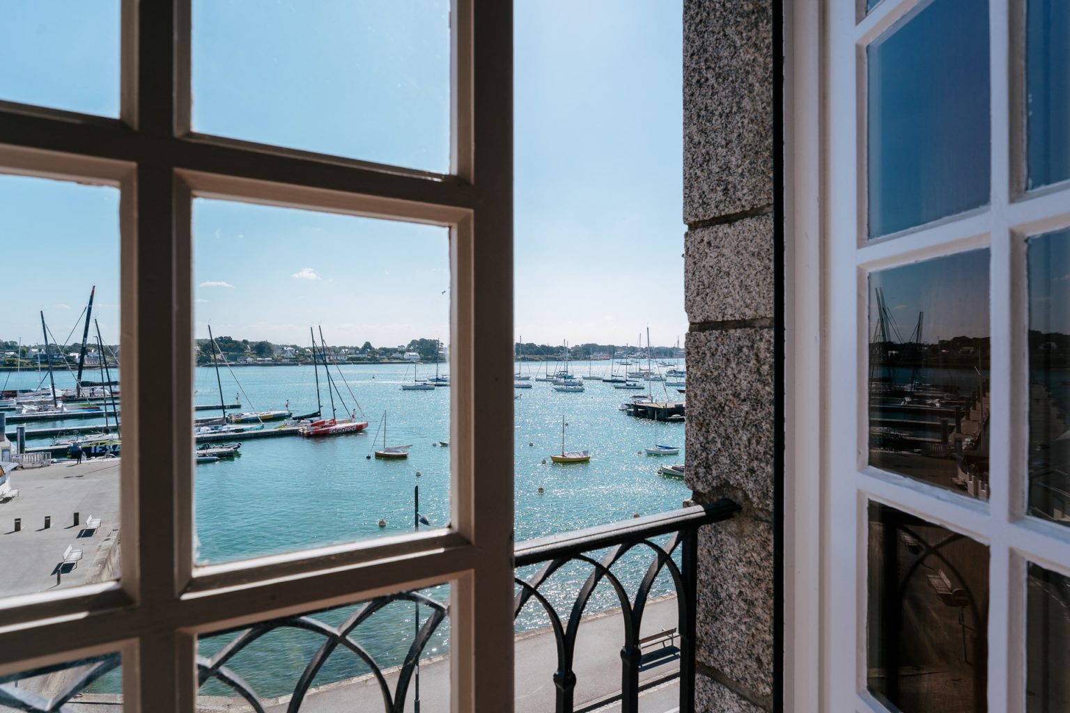 Photographie d'une fenêtre ouverte avec vue sur le port de la Trinité sur Mer