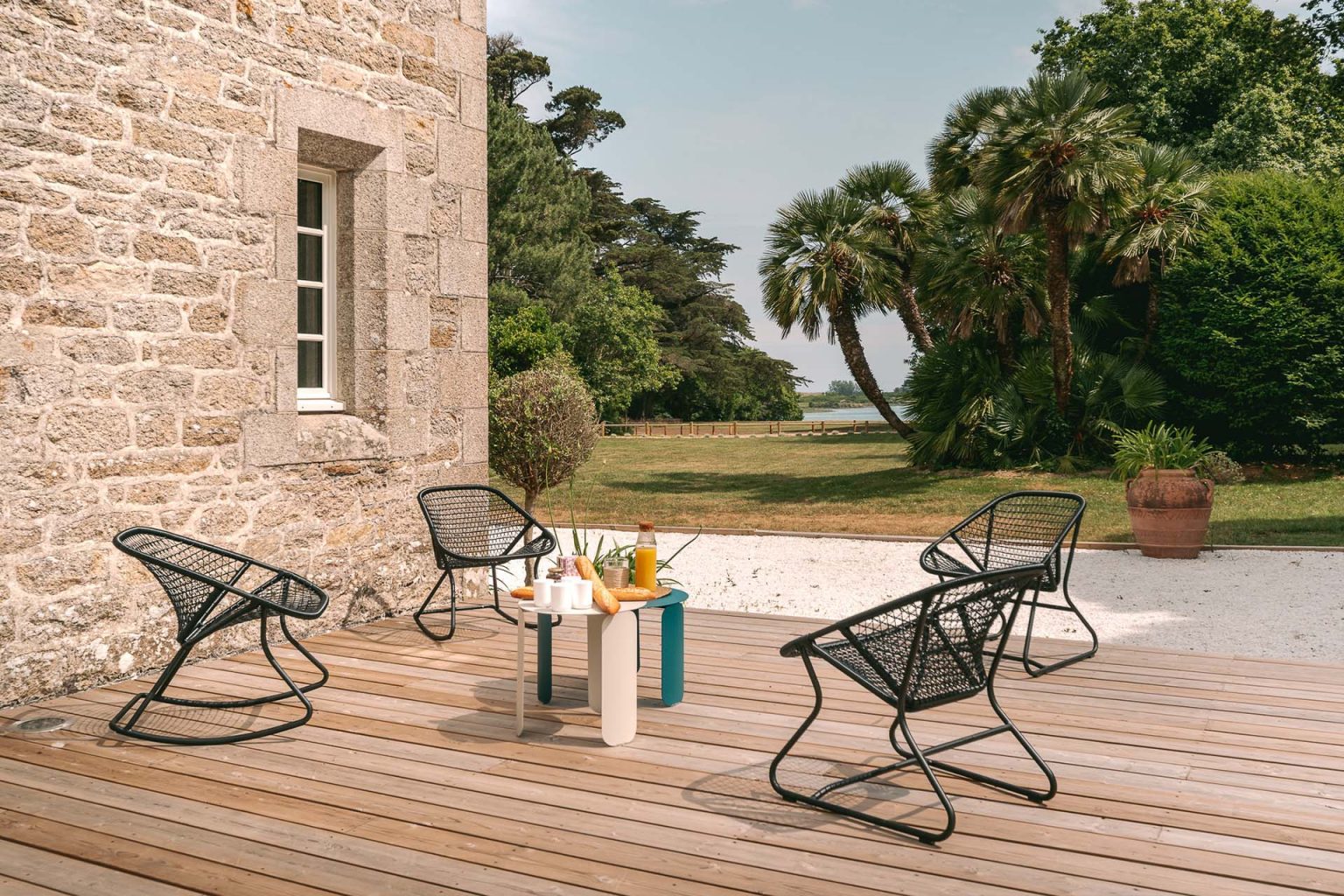 Photographie d'un salon de jardin avec un petit déjeuner servi, sur la terrasse d'un gîte en Bretagne